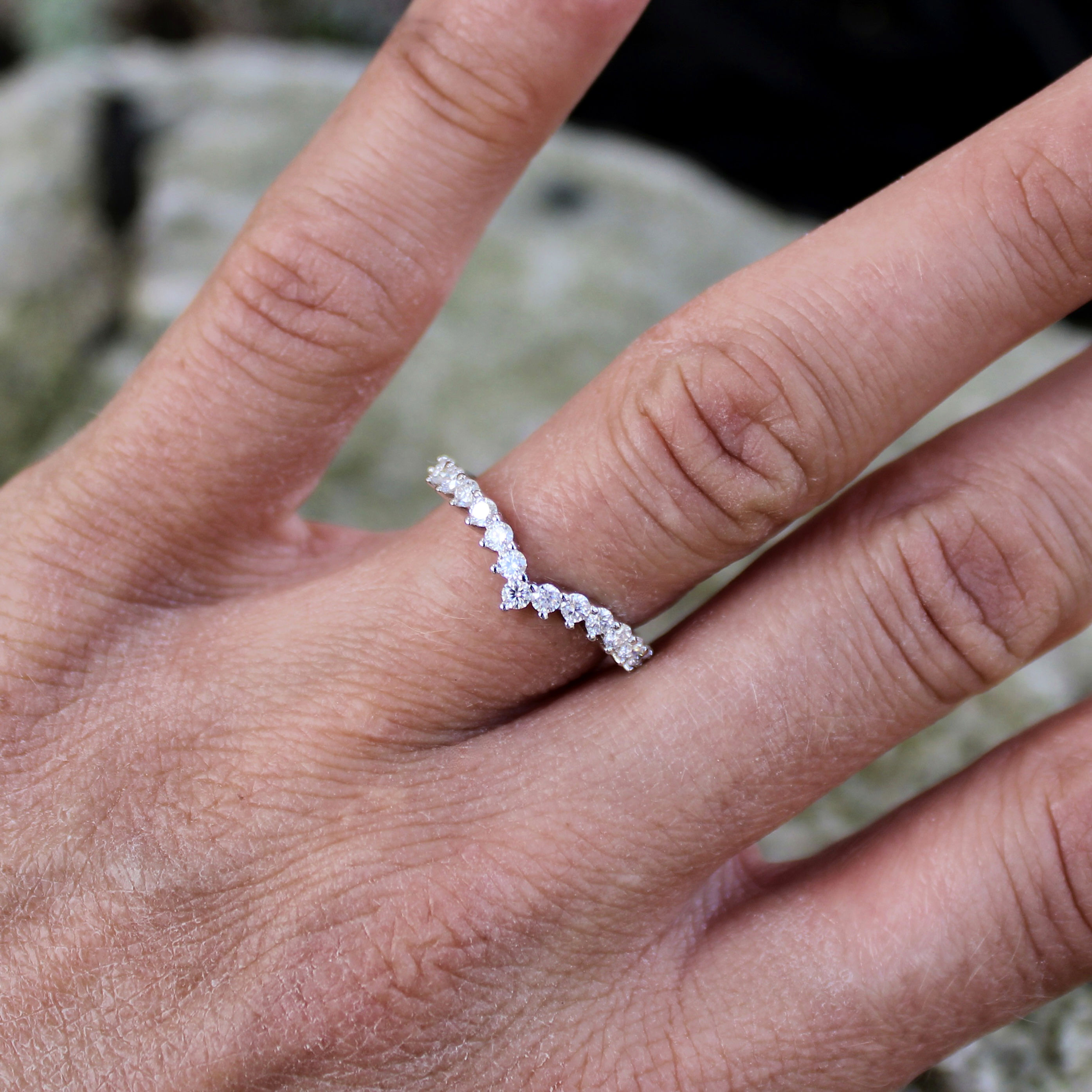 Clear stones in a shallow V worn on a finger.