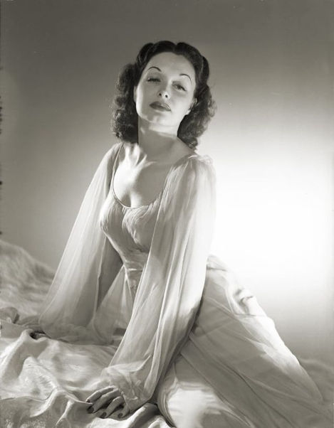 a black and white photo of a woman in a white dress