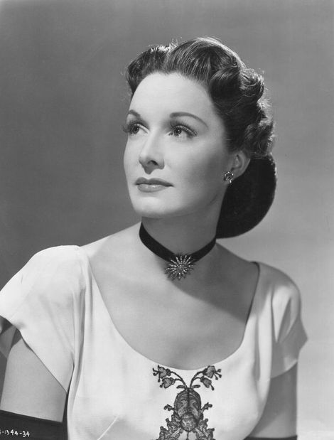 a black and white photo of a woman wearing a choker