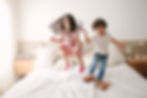 crianças pulando na cama