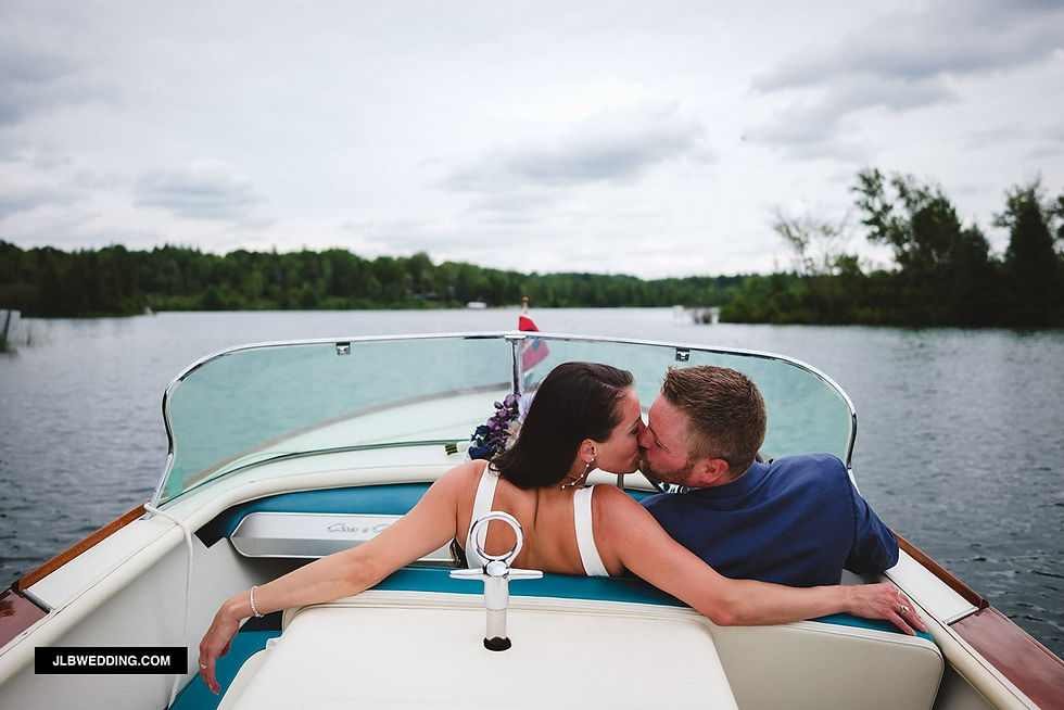 bride & groom kissing on a boat