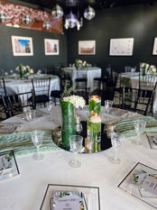 a table set for a party with a candle in a vase