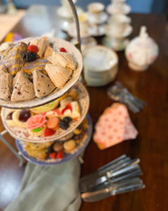 three plates of food are on a table including scones