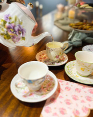 a cup of tea is being poured from a teapot