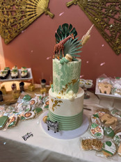 a green and white cake with a giraffe and zebra on top