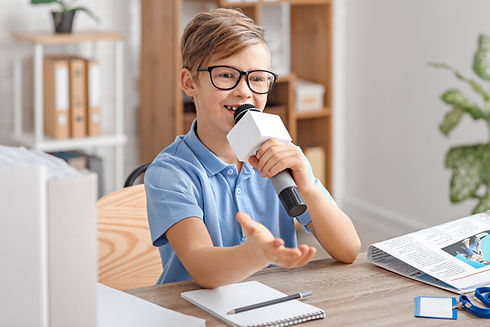 Little journalist with microphone having an interview in office.jpg