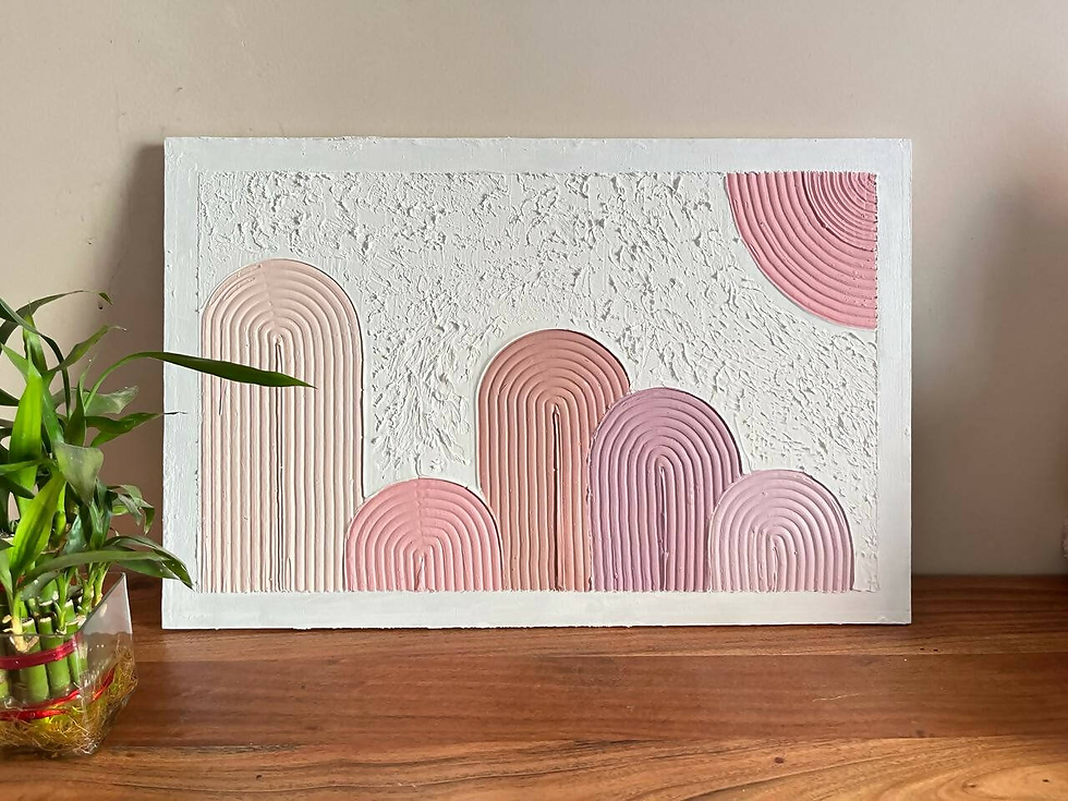 Textured artwork with pastel pink arches on a white background, next to a small bamboo plant on a wooden surface. Calm ambiance.