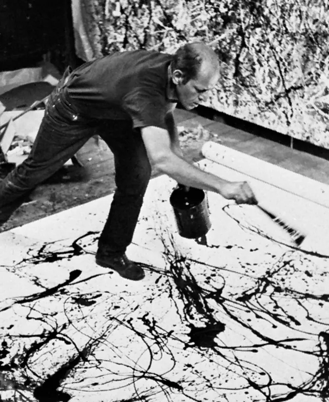 Man splattering black paint onto a large canvas on the floor in an art studio. Energetic art style, abstract patterns in a creative setting.