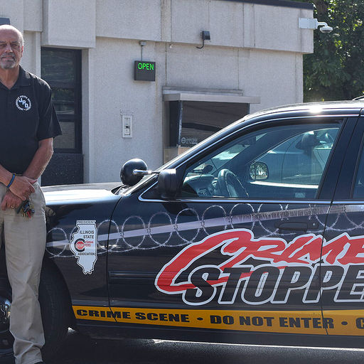 Loren Hamilton standing beside Crime Stoppers vehicle, archival photograph