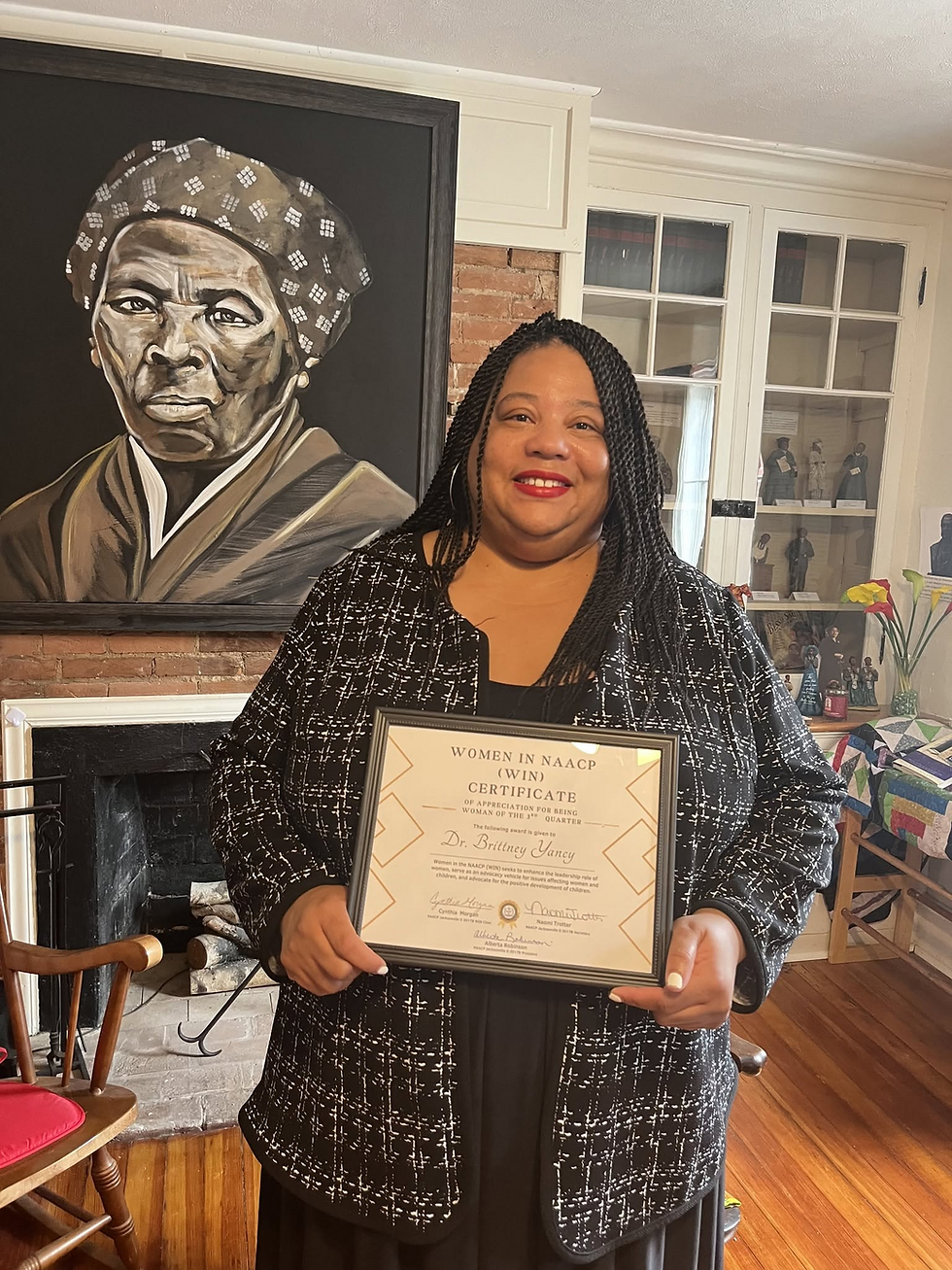 Dr. Brittney Yancy holds her Women in NAACP recognition certificate