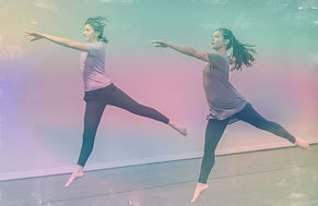 Alt text: two dancers jump with one leg extended behind them