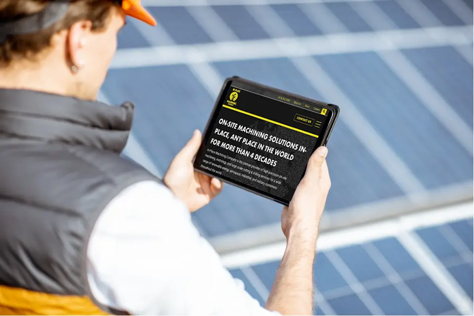 Worker outside holding tablet with solar panels in the background