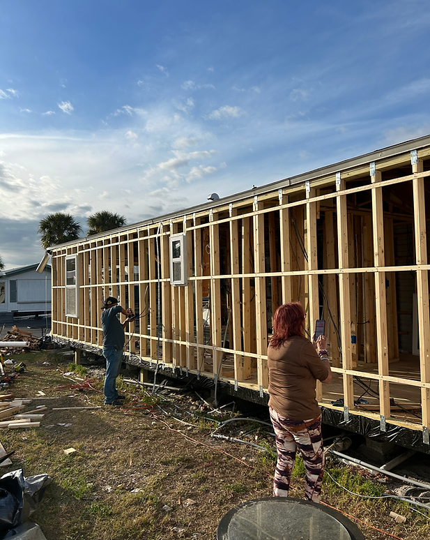 Trabajadores realizando reparaciones de mobile home en estructura de madera.