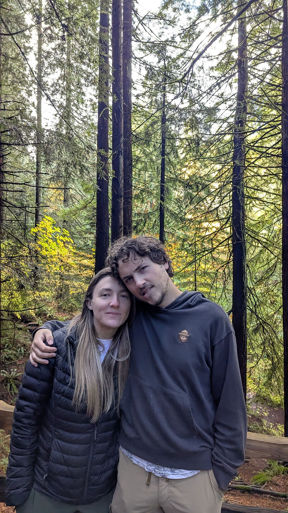 two people posing in a redwood forest