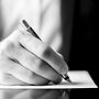 Low angle black and white image of a male hand holding a fountain pen as though writing on