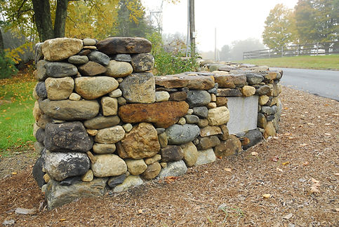 A natural fieldstone wall and pillars along a driveway in Conway, MA
