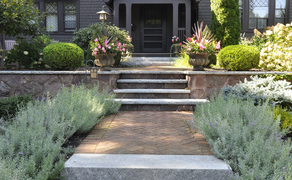 Fieldstone retaining walls with granite capstones, and steps, with brick paver walkways at a home in Greenfield, MA