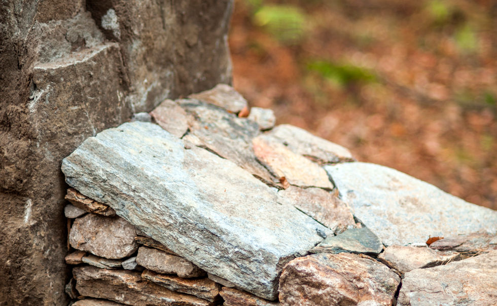 A creative stone bridge over a stream, by stonemasons at CountryScape LLC