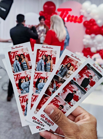 da40d5 f58f9b0d00ac4936a6699a9bba1e3d43~mv2 Close-up of a guest holding a 2x6 photo booth strip printout captured at a special event.