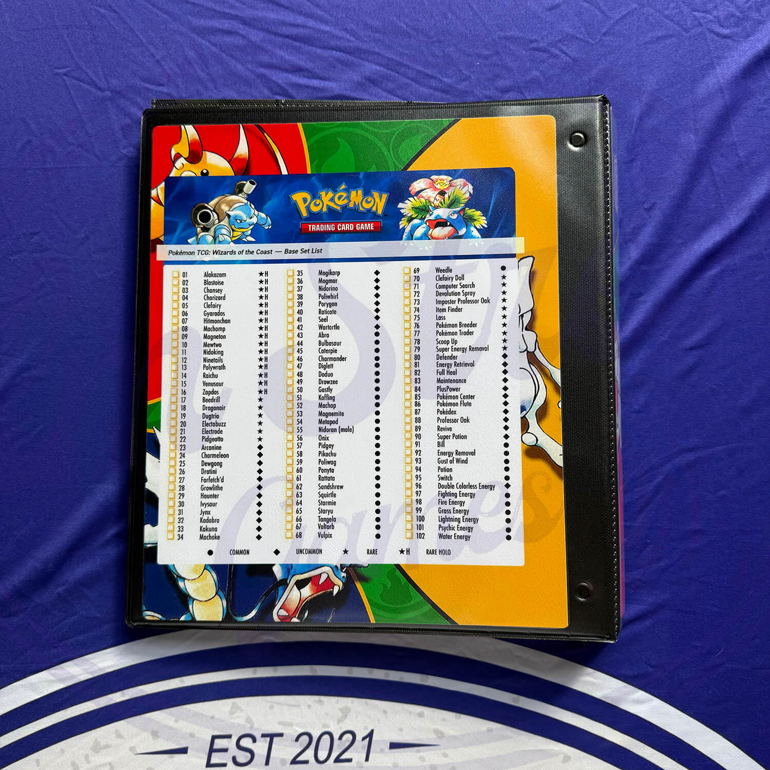Back of Pokémon binder with a Base Set checklist insert, featuring Blastoise, Venusaur, and Pokémon logo.