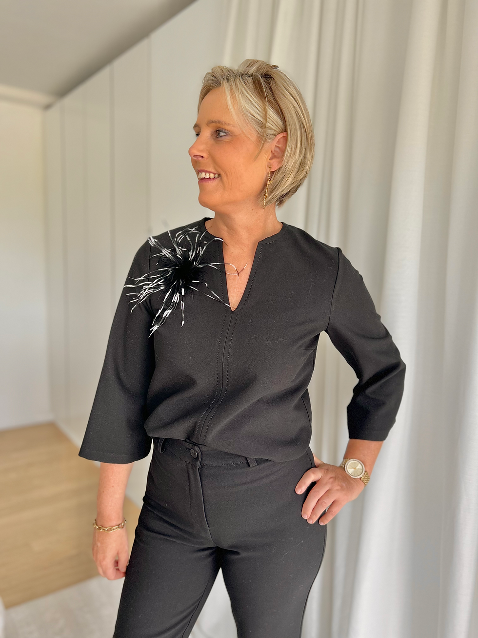Thumbnail: 64892 Zwarte blouse in geklede stof met trompetmouw en broche Atmos