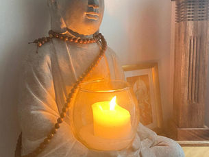 Le bouddha en pierre avec une bougie allumée qui est près de la porte d'entrée du studio comme une présence.  Un symbole . On rentre en soi pour s'offrir du temps.