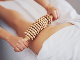 Madérothérapie sur les cuisses au Namasté Studio à Pau, rouleau en bois pour sculpter la silhouette et réduire la cellulite.