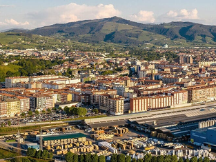 Vista panorámica de Torrelavega con el centro de la ciudad, áreas residenciales y el entorno natural de Cantabria al fondo.