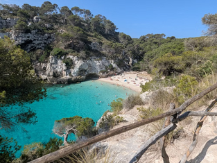 Vista panorámica de Cala Macarella en Menorca con aguas turquesas y paisaje natural mediterráneo