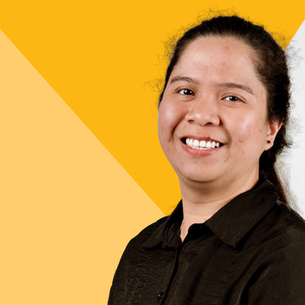 Trixia smiling in front of a yellow background