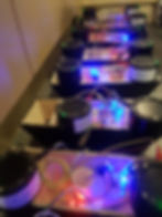 Several pairs of small round speakers attached to arduino and wireless modules operating in-sync with blue and purple LED lights