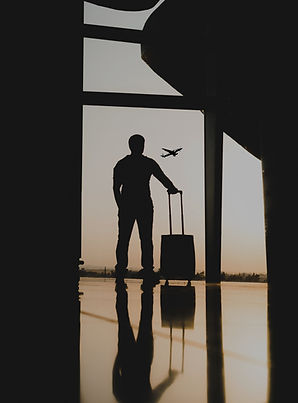 silhouette of man holding luggage inside
