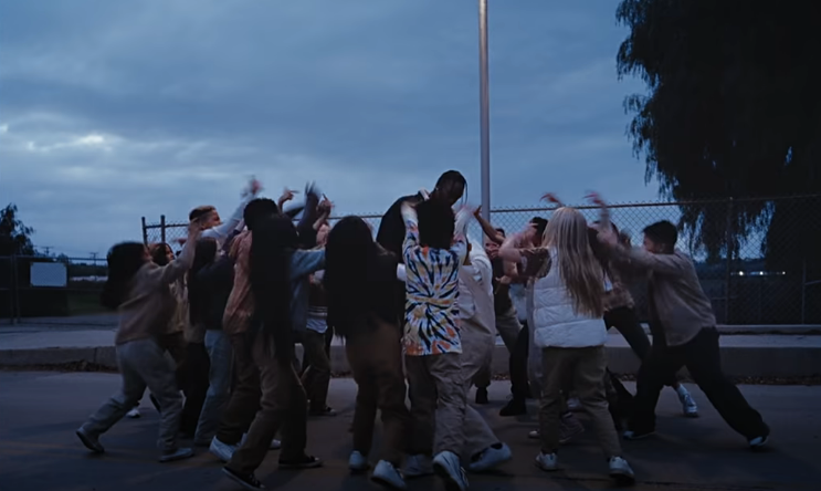 Travis Scott rodeado por niños en video TKN Rosalía