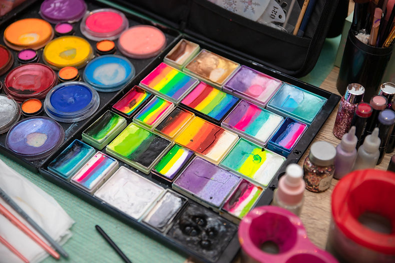 Colourful paint boxes and tubes with paints on a table. Paints and brushes for make-up, fo