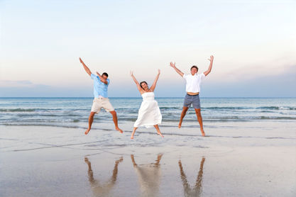 Family of 3 jumping for a funny photo on the beach in Ponce Inlet, Florida