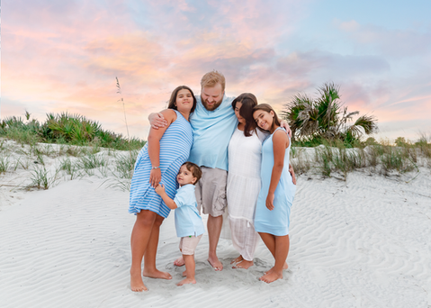 Family posing for photos on the beach