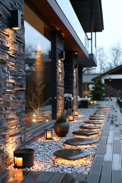 Modern outdoor pathway illuminated with warm lighting features slate stepping stones and lush potted plants, creating a tranquil and stylish entrance.