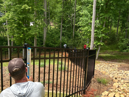 Brothers Fences employee installing black aluminum fence in Stockbridge, GA