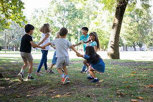 happy-children-playing-together-outdoors-dancing-around-grass-enjoying-outdoor-activities-