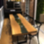 Mesa de jantar em madeira maciça com detalhe em vidro, acompanhada de cadeiras pretas