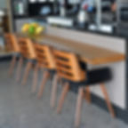 Aparador em madeira maciça, acompanhado de cadeiras que combinam madeira e estofado preto