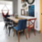 Mesa de jantar de madeira maciça combinada com diferentes tipos e cores de cadeiras.