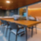 Mesa de jantar em madeira maciça com pés em inox, acompanhada de cadeiras trançadas