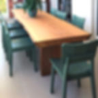 Mesa de jantar em madeira maciça com pés em madeira, acompanhada de cadeiras verdes