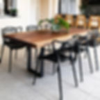 Mesa de jantar em madeira maciça de Jatobá com pés em aço carbono, acompanhada de cadeiras de pretas