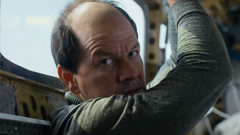 Bald Mark Wahlberg is handcuffed inside a plane