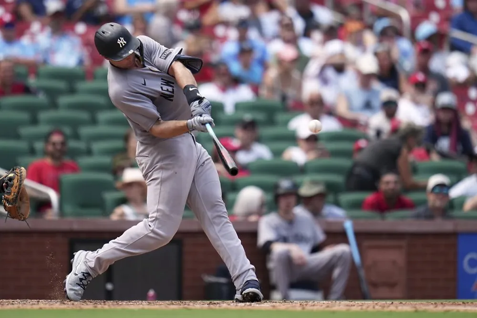 a man in a baseball uniform swings a bat inside a baseball stadium