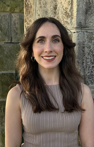 A photograph of Ruby from the shoulders up - a caucasian women with long brown hair, hazel eyes and big smile.