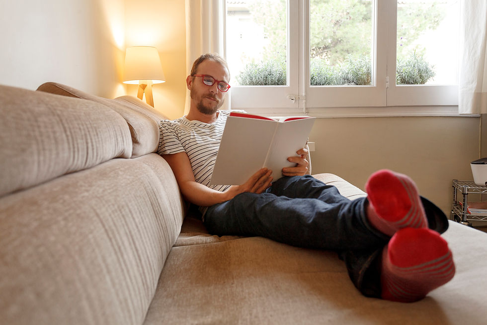 man on a couch reading a book