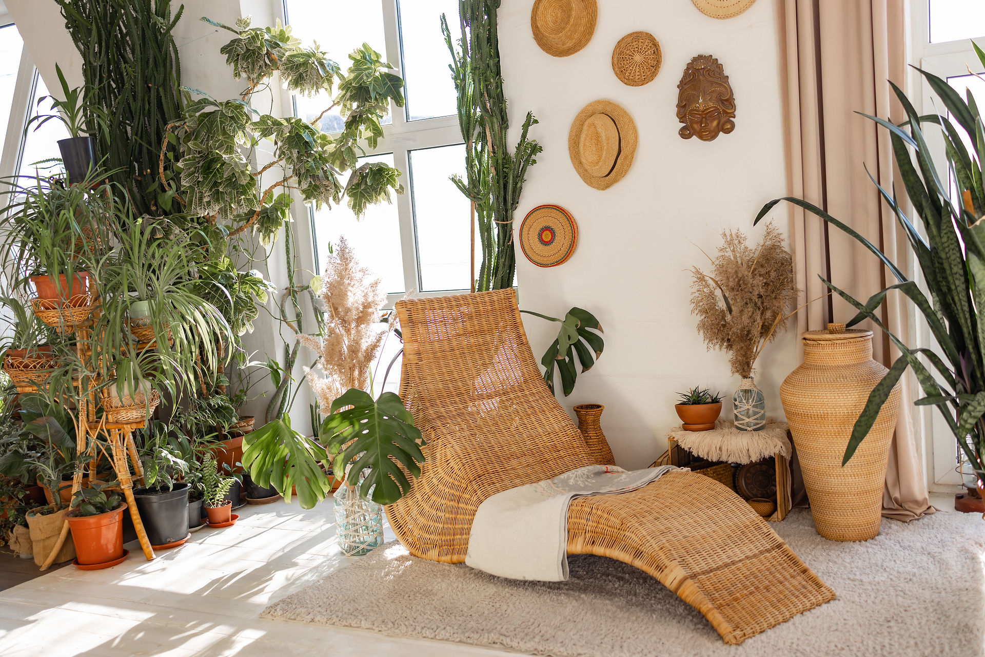 natural living room corner with wicker natural wood chair and lots of plants